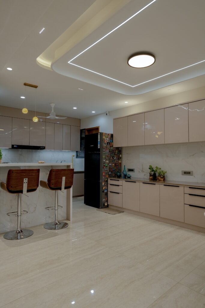 Glossy modular kitchen cabinets and countertop in Ahmedabad home
